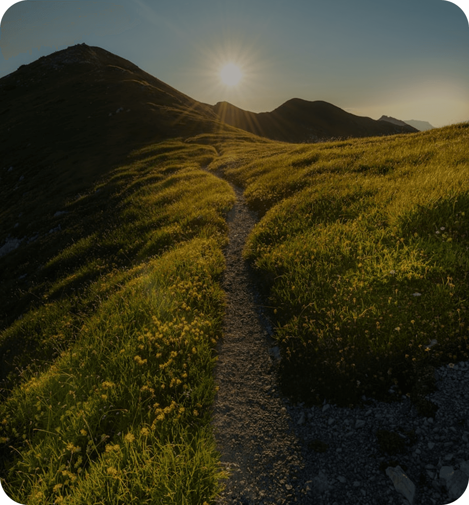 A sunny mountain path through green hills