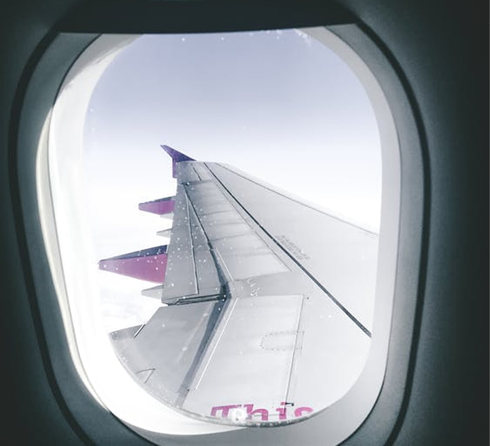 Airplane wing seen through a passenger window
